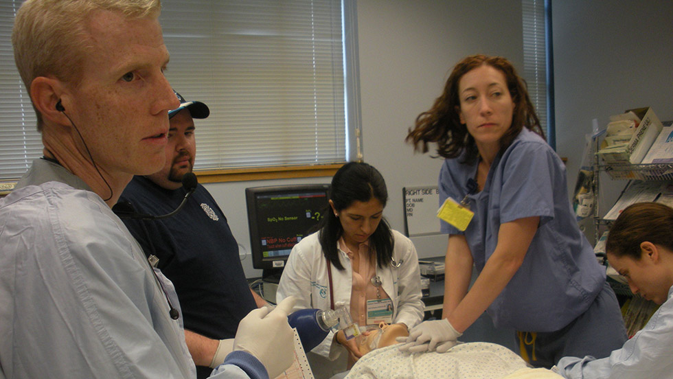 several doctors and hospital workers doing a drill with a dummy patient