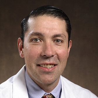 man smiling wearing a lab coat