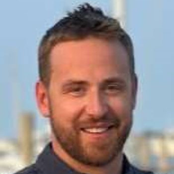 man smiling wearing a dark shirt