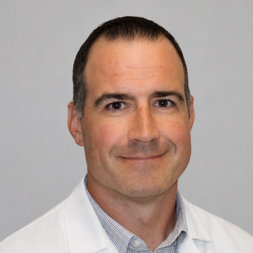 smiling man wearing a white lab coat