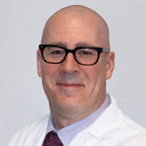 man smiling with glasses and a white lab coat