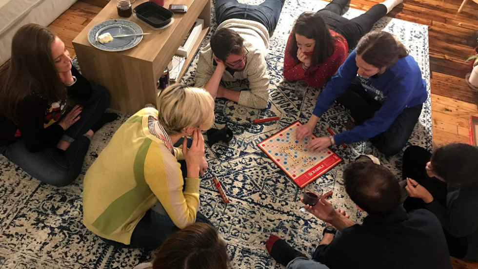 several people sitting on the floor playing Scrabble